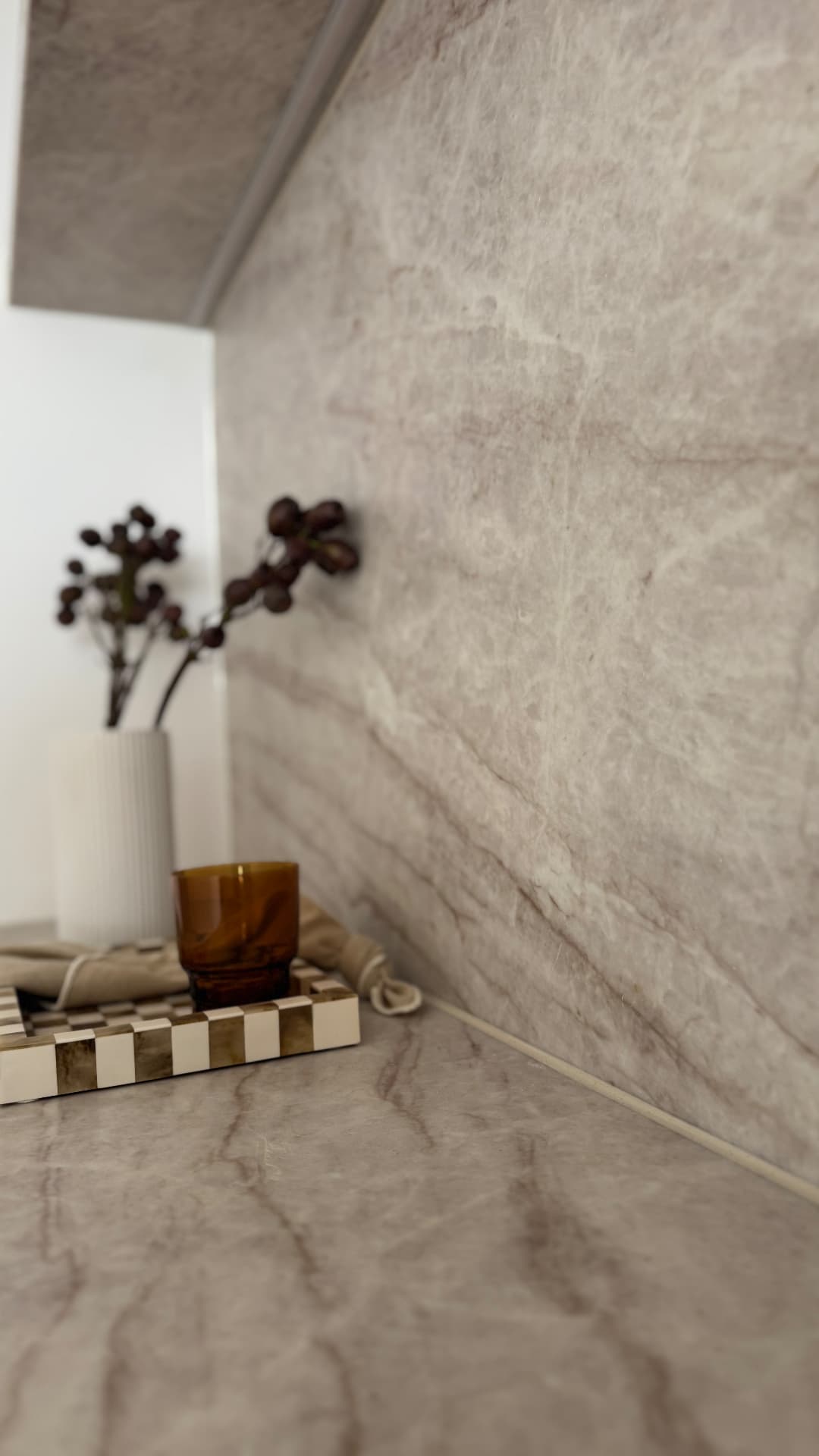 Close-up of sealed joint between stone benchtop and splashback