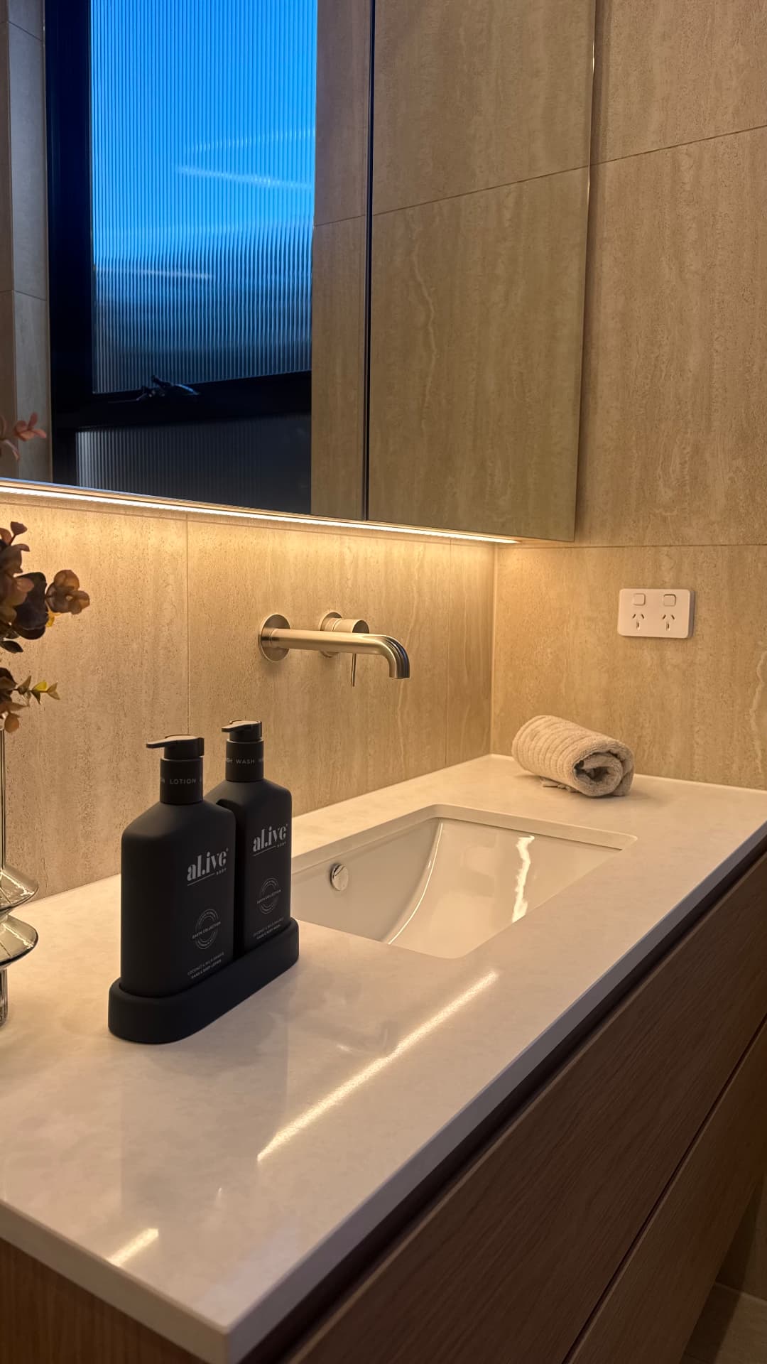 Bathroom vanity with sealed basin, benchtop and travertine splashback