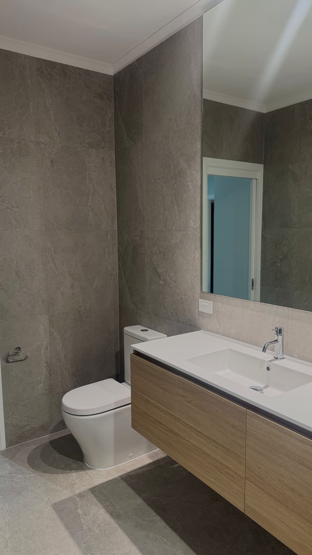 Bathroom with sealed vanity, benchtop and tiled wall junctions