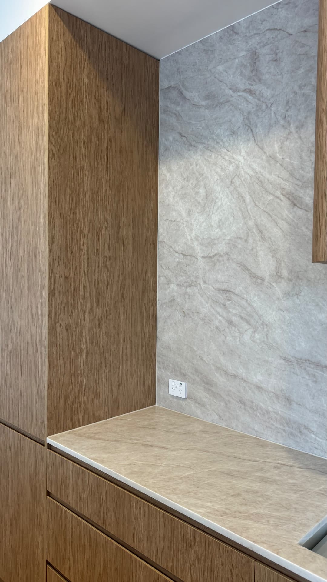 Kitchen corner with sealed stone splashback and timber cabinetry