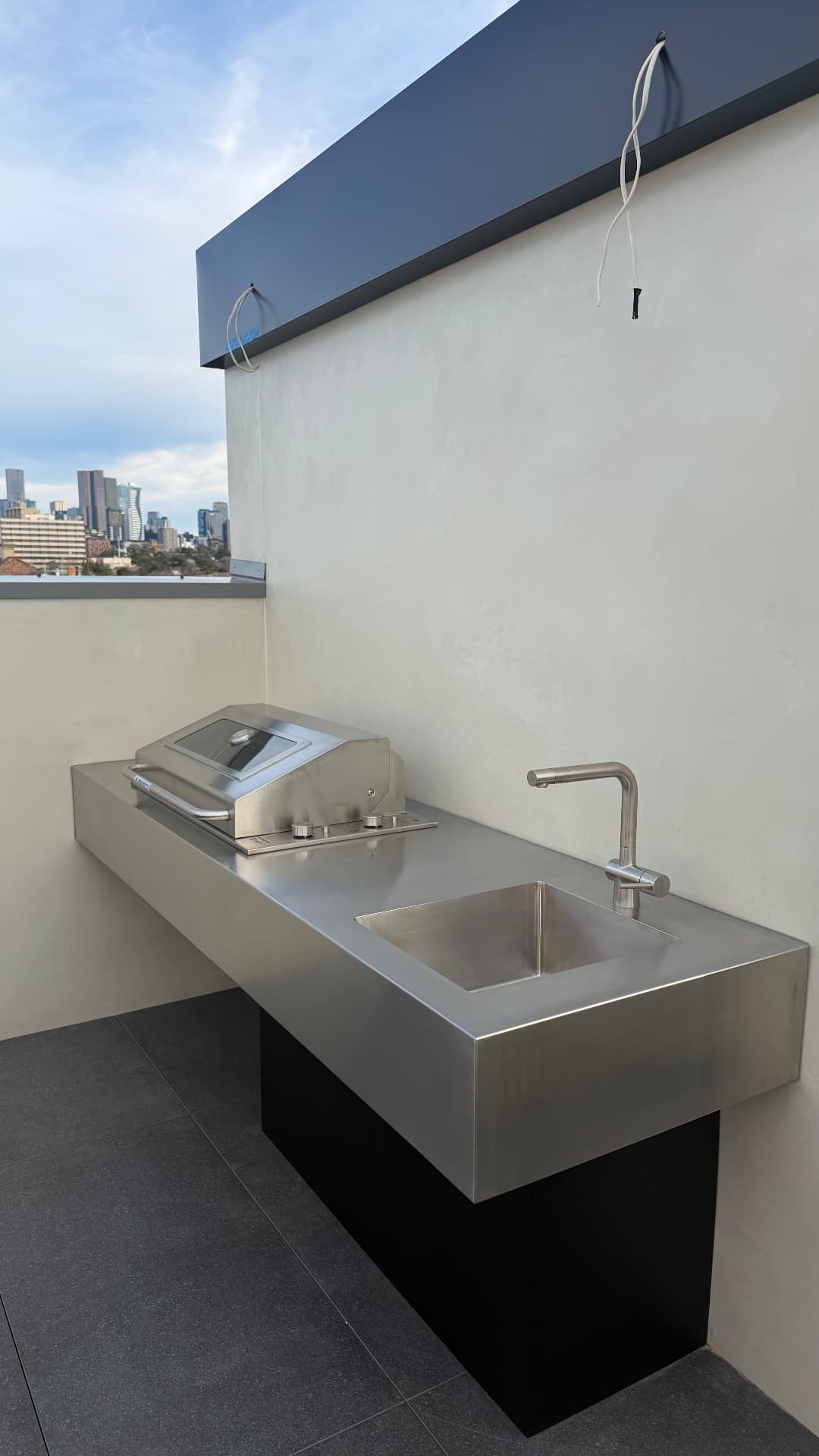 Rooftop outdoor kitchen with sealed stainless benchtop and wall
