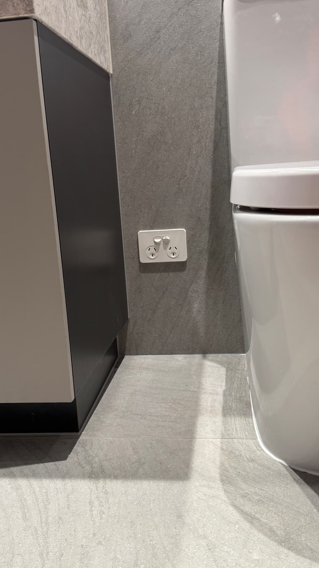 Toilet and vanity sealed to tiled walls and floor
