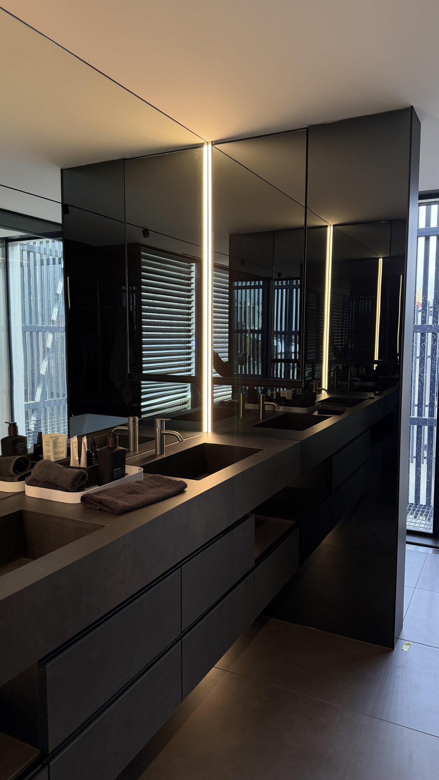 Dark stone vanity with mirrored joinery sealed by Seal Caulking Experts in Melbourne
