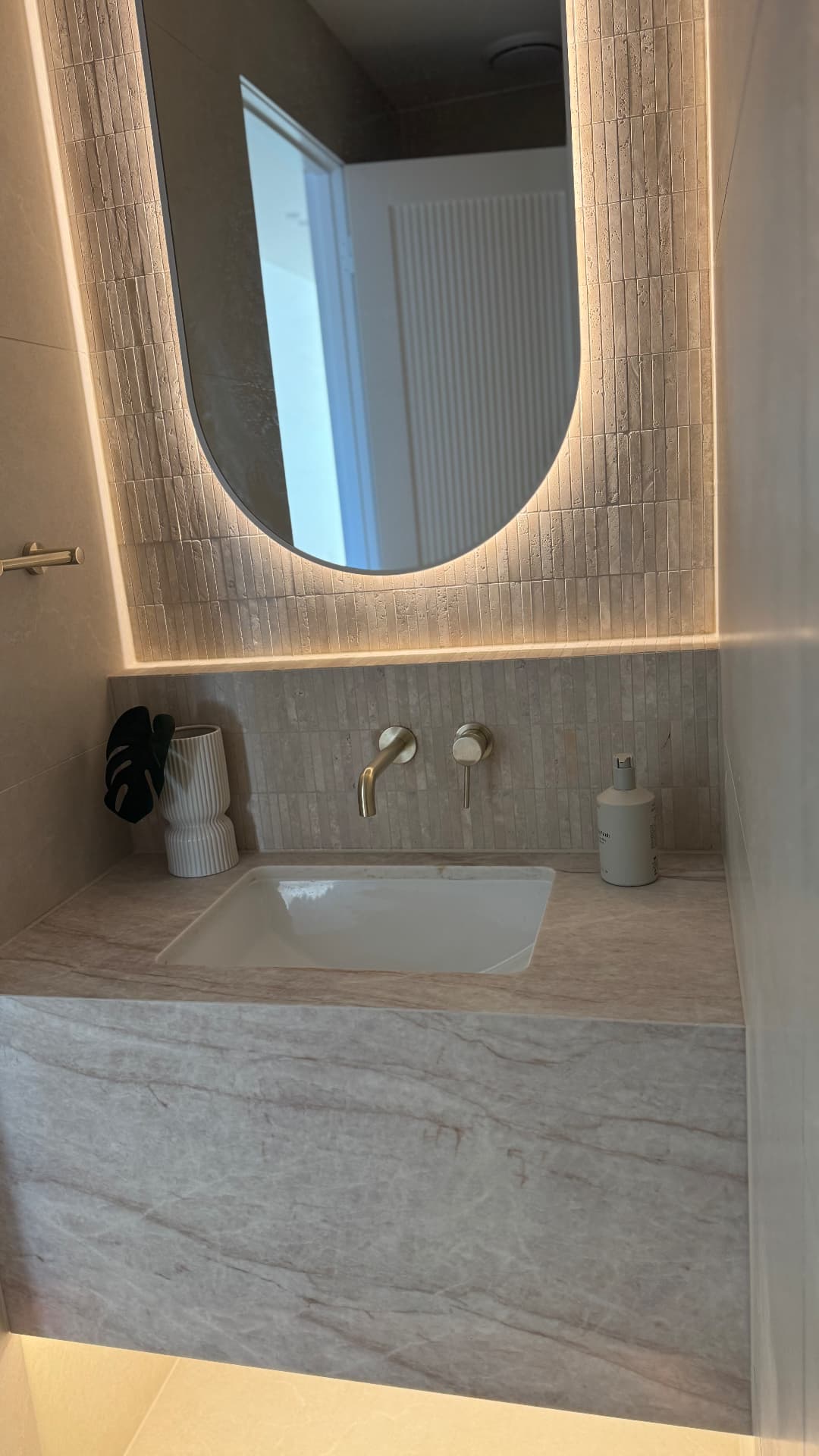 Powder room vanity with sealed stone benchtop and mosaic splashback
