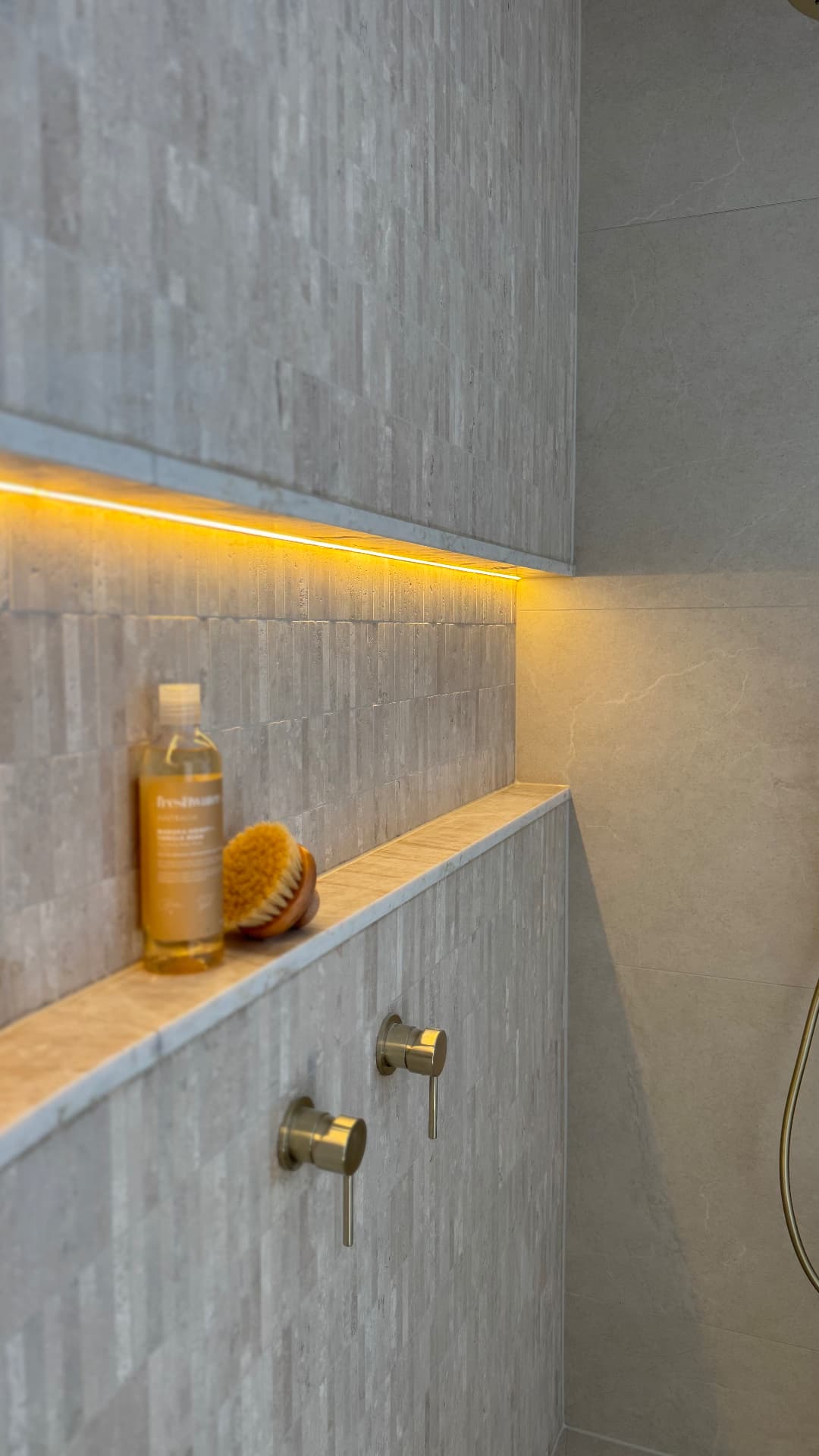 Shower niche with sealed stone shelf and lit recess