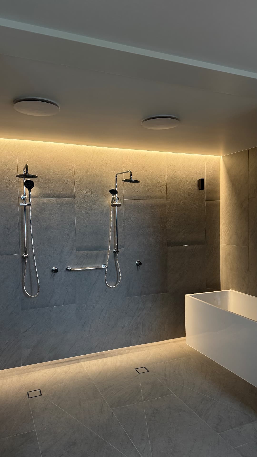 Double shower with sealed tiled walls and bath surround