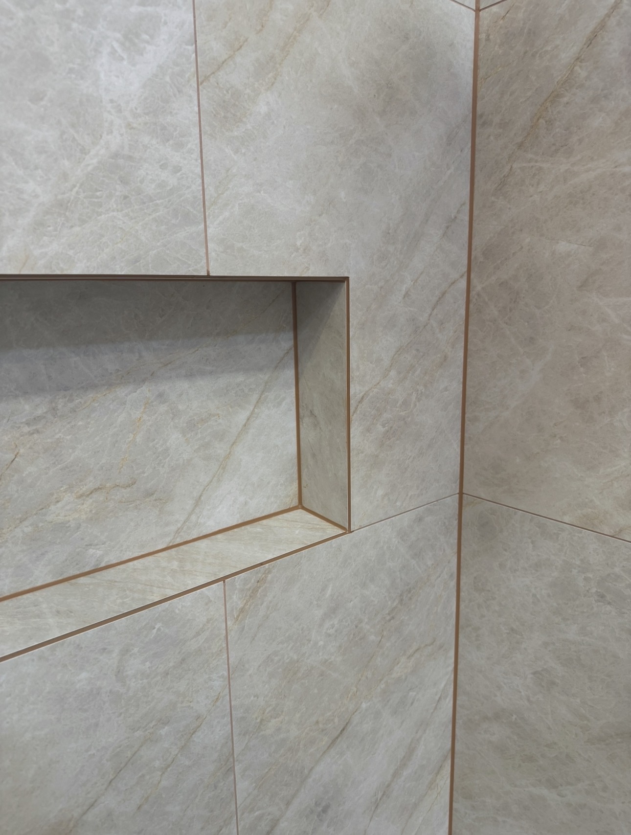Shower niche with sealed stone-look tile junctions
