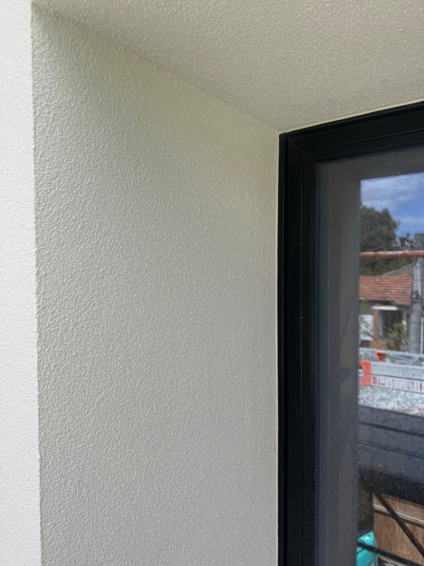 External render wall sealed to black window frame
