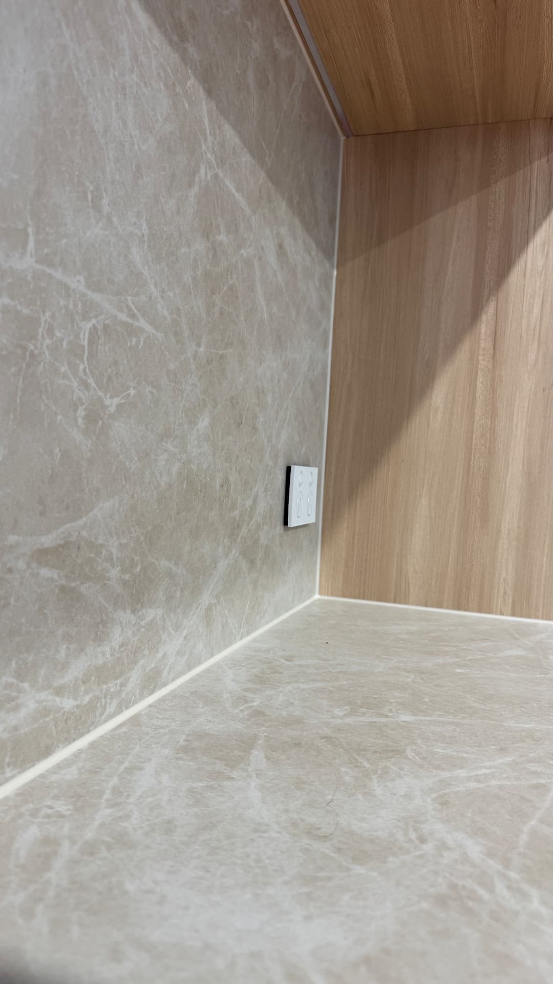 Close-up of sealed corner between stone splashback and benchtop