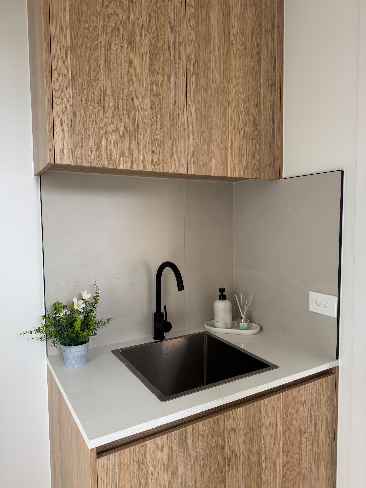 Laundry sink with sealed glass splashback and stone top