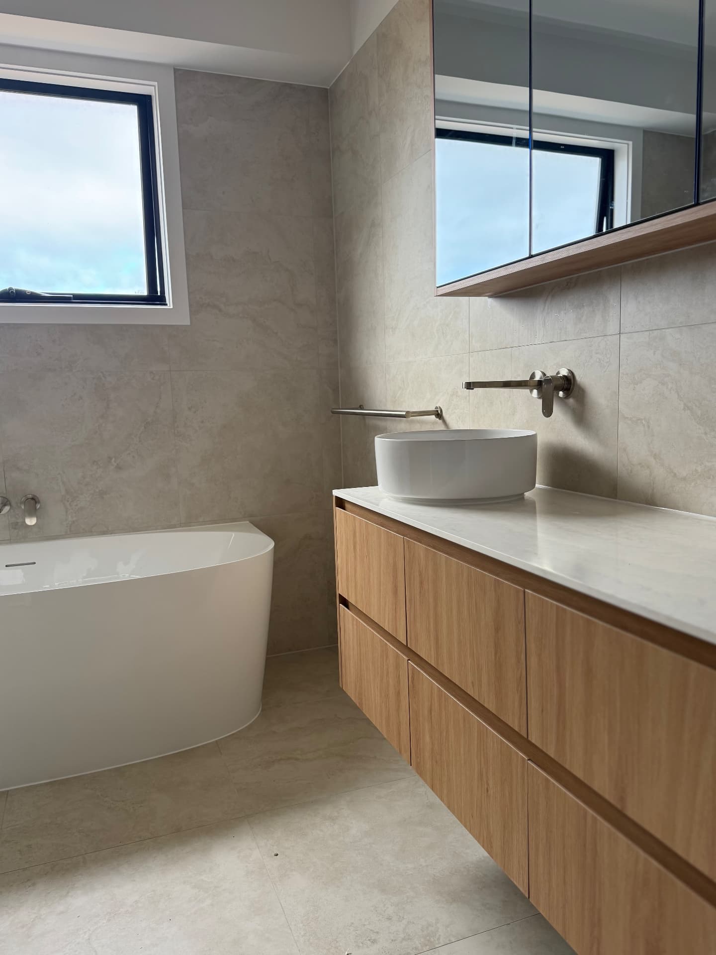 Bathroom with sealed timber vanity, stone benchtop and freestanding bath