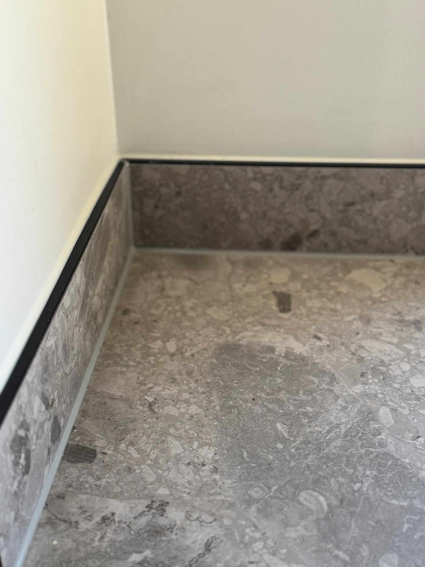 Shadow-line skirting sealed above terrazzo tiled floor