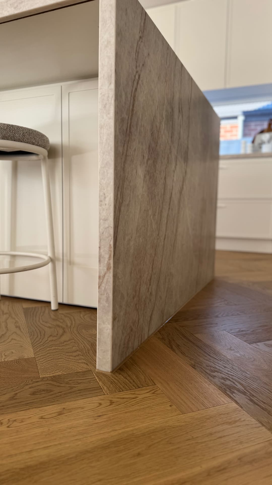 Stone kitchen island waterfall sealed to herringbone floor