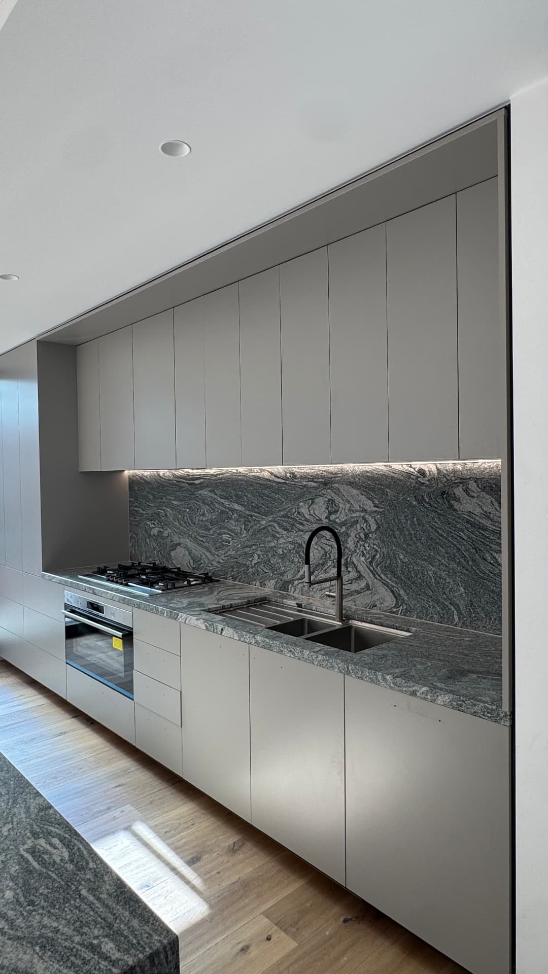 Kitchen with sealed granite splashback, benchtop and cabinetry