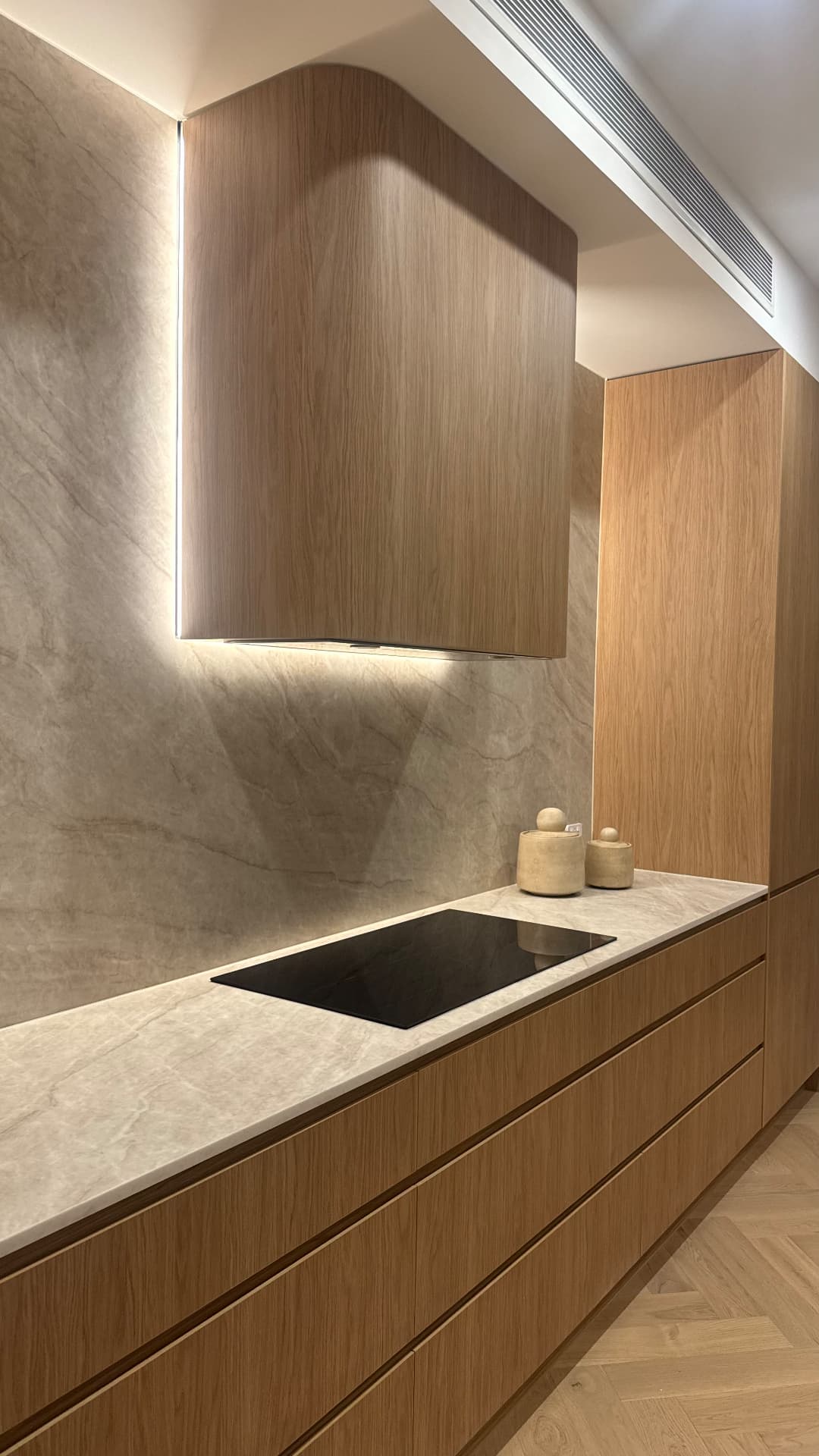 Oak kitchen with sealed stone splashback, benchtop and rangehood joints