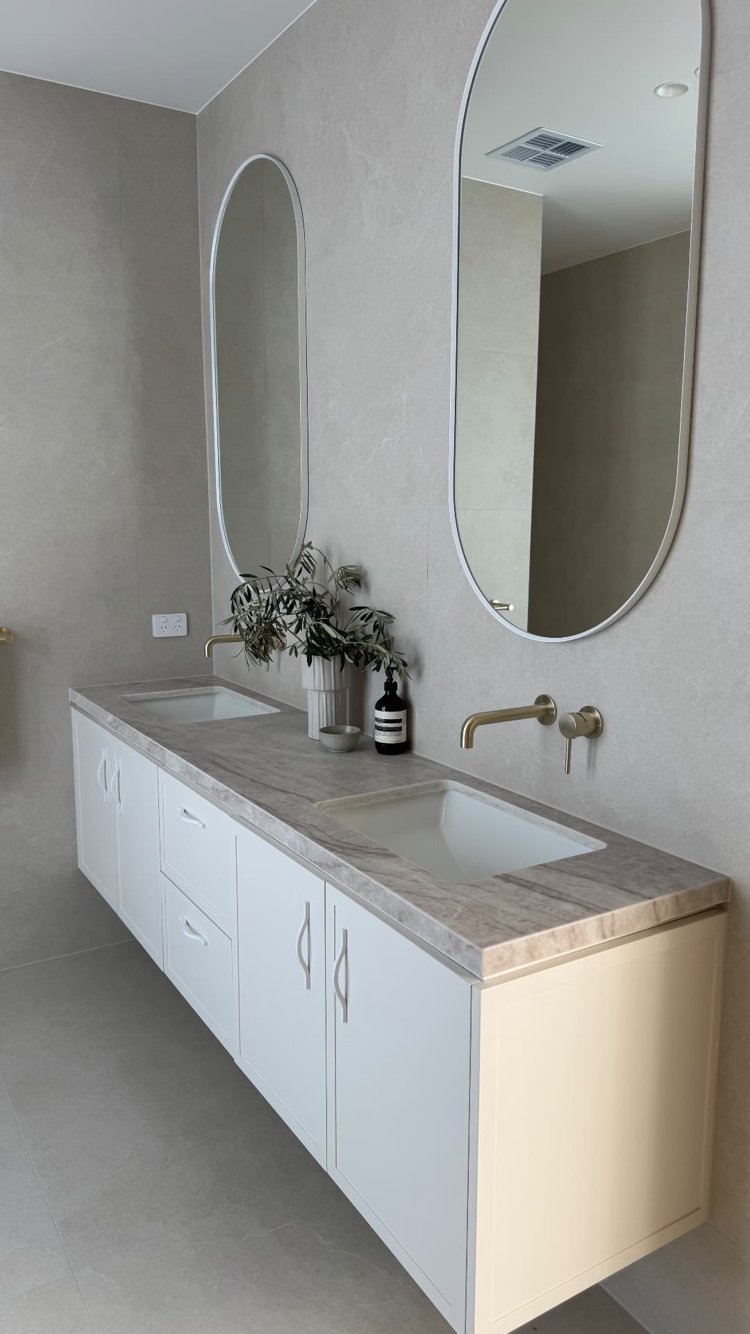 Double vanity with sealed stone benchtop and tiled walls