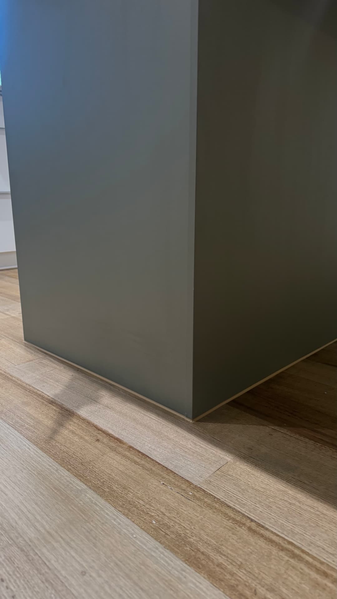 Sealed junction between kitchen island panel and timber floor