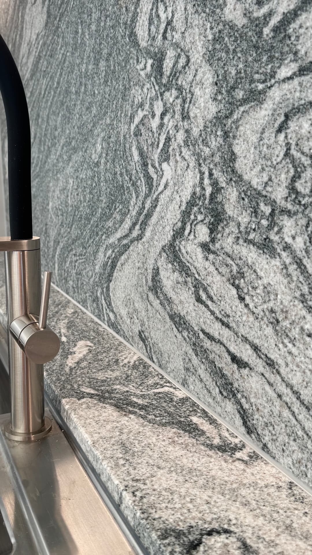 Close-up of sealed junction between granite splashback and benchtop