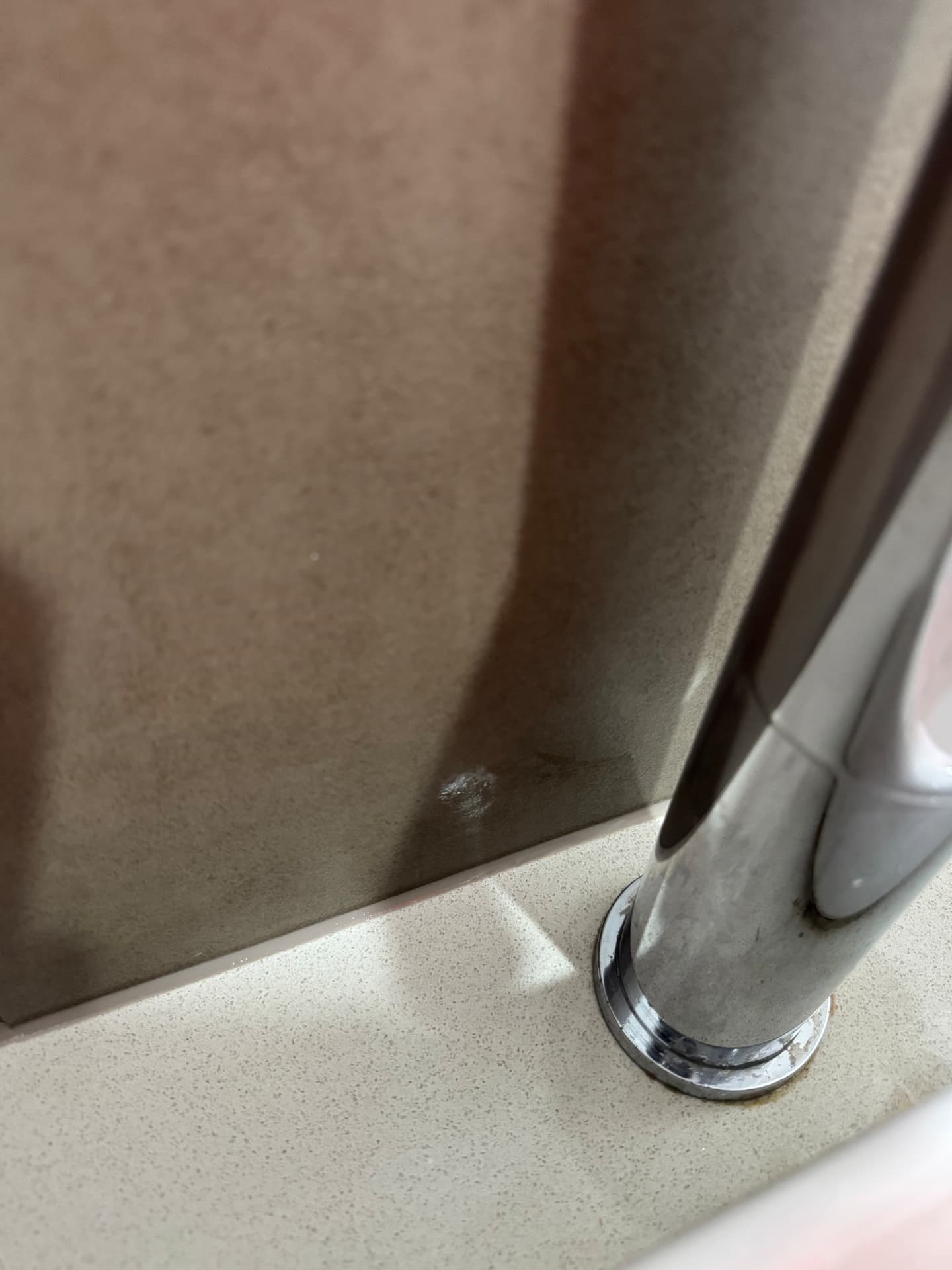Close-up of sealed junction between stone splashback and benchtop