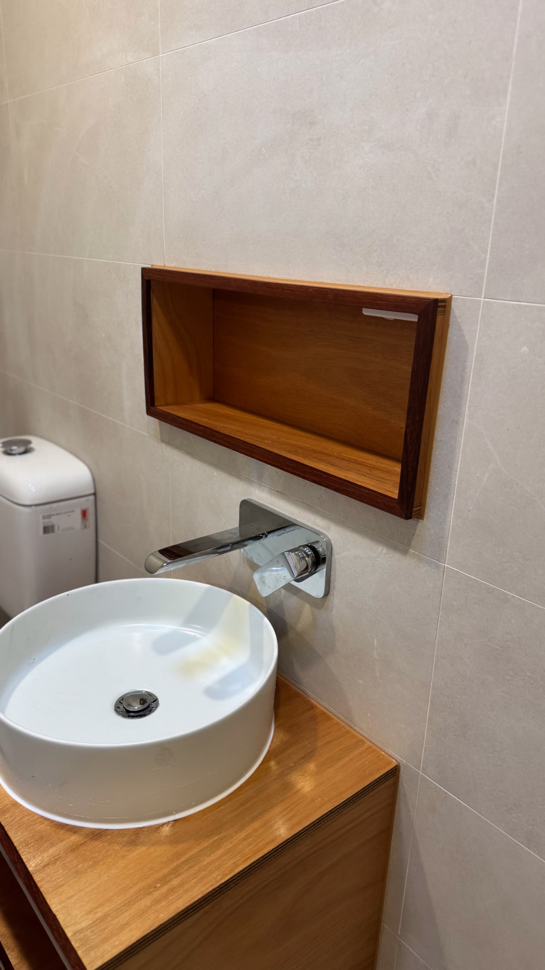 Powder room with sealed timber niche and wall-hung tapware