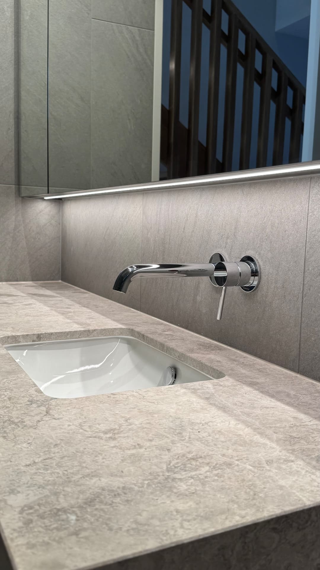 Vanity with sealed stone benchtop, basin and tiled splashback
