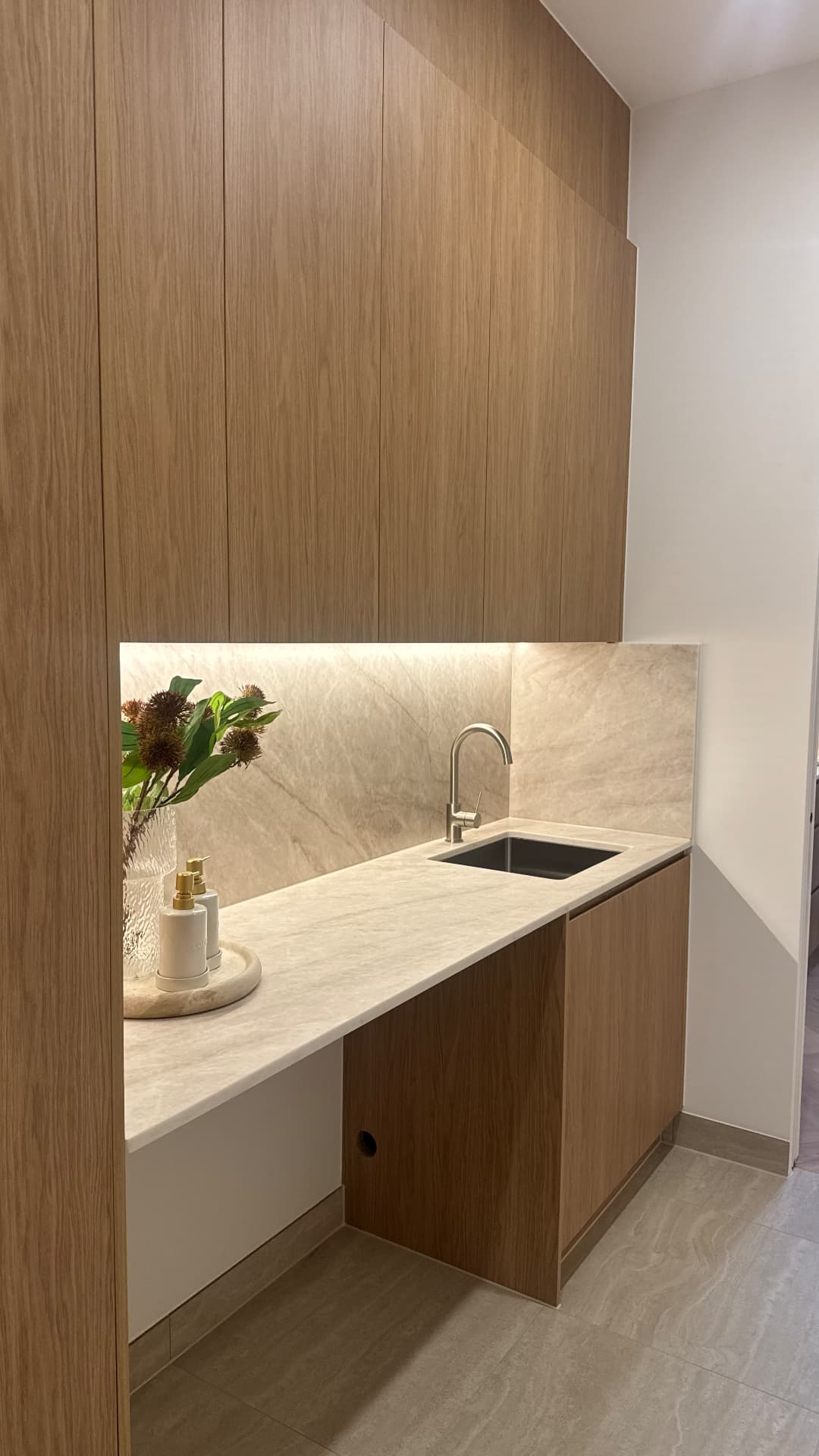 Laundry with sealed stone benchtop, sink and timber cabinetry