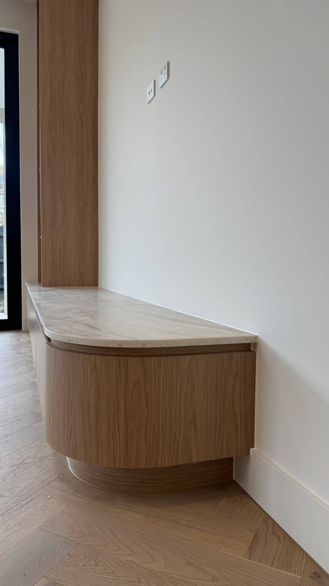 Curved joinery bench with sealed stone top and skirting junction