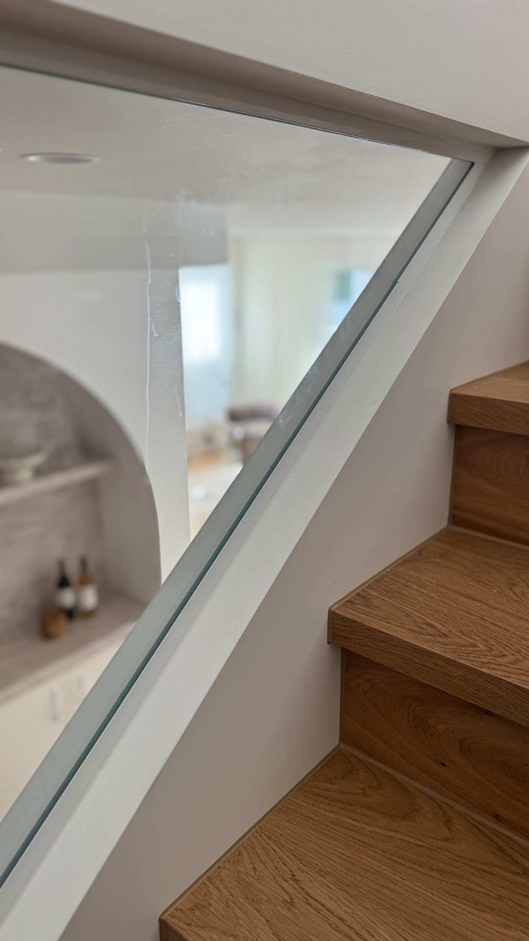 Sealed glass balustrade junction beside timber stair treads