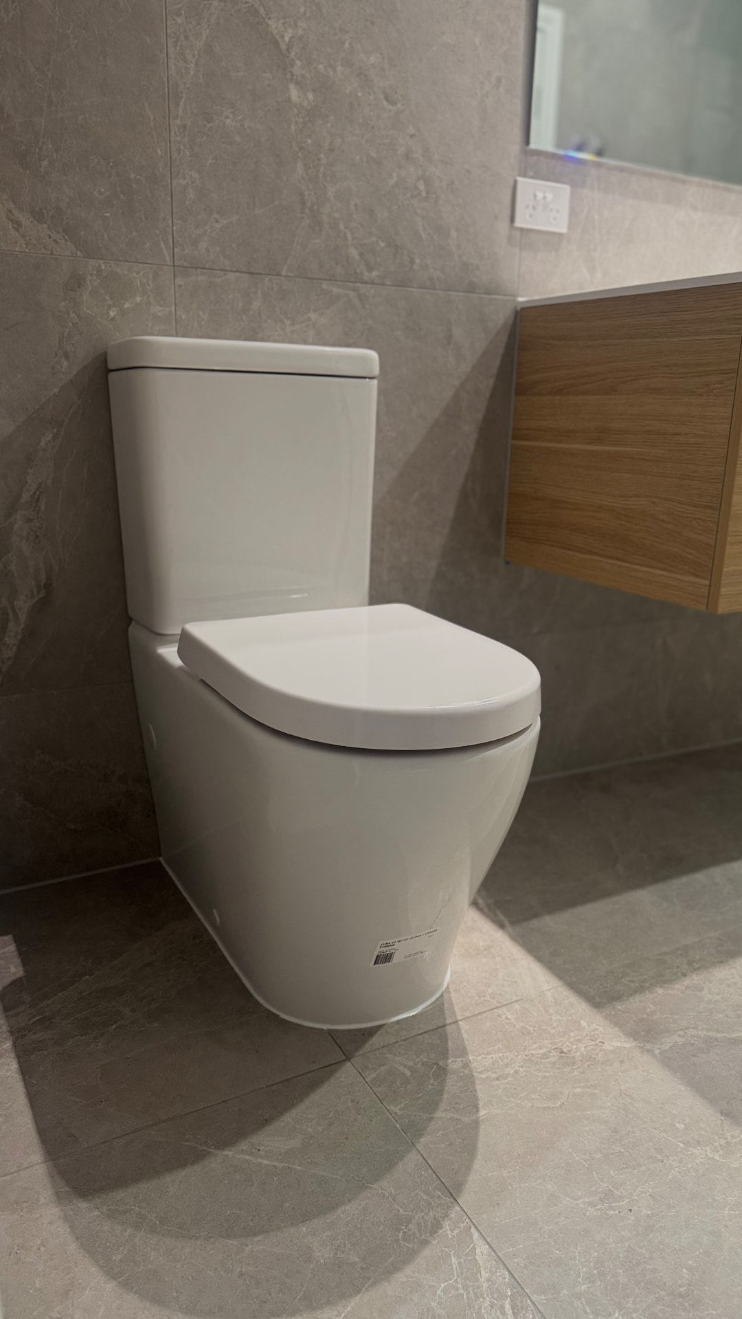Toilet sealed to the tiled floor with a clean silicone bead