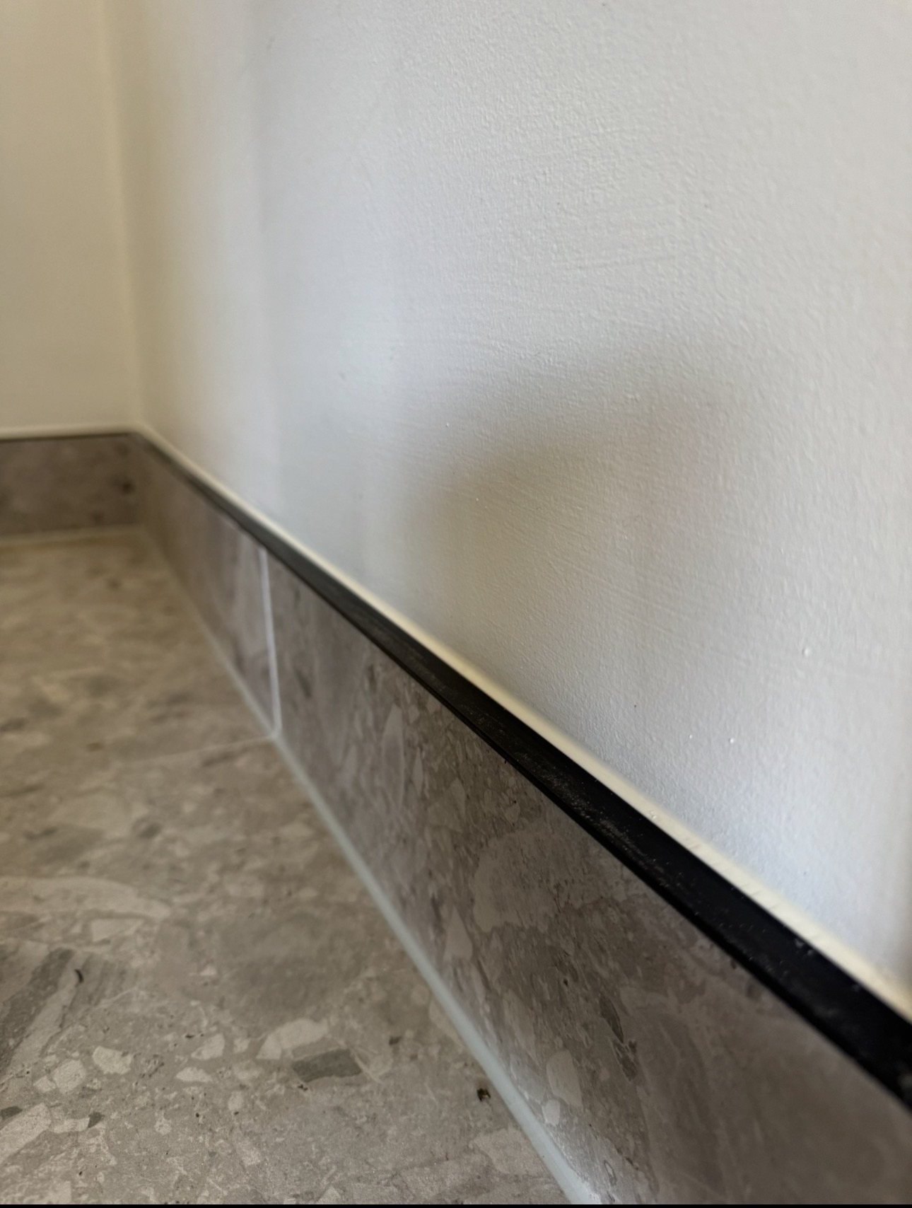 Skirting board sealed to terrazzo tiled floor